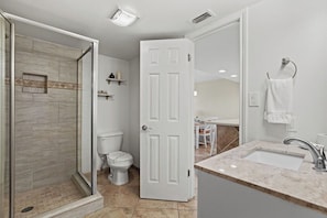 Un baño moderno con ducha, inodoro y lavamanos.