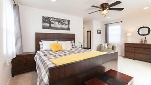 A bedroom with a bed, bedside tables, a ceiling fan, a dresser, and a window with curtains. - Family Friendly Beach House - Rare Central Air Conditioning, Close to Town/Beach (Carlsbad)