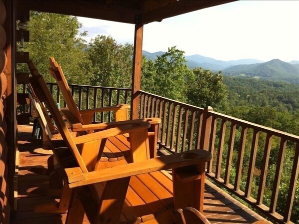 Enjoy outdoor dining or relaxation on this elevated deck with scenic views of the surrounding landscape and distant mountains.