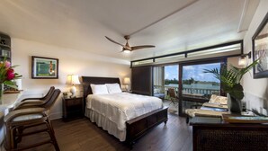 A bedroom with a large bed, a ceiling fan, a view of the outdoors, and a balcony with chairs. - Oceanview #105 at Hana Kai Maui - Sweet Studio Unit, Great View and Decor! (Hana)