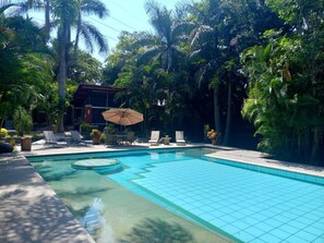 Een buitenzwembad, parasols voor strand/zwembad