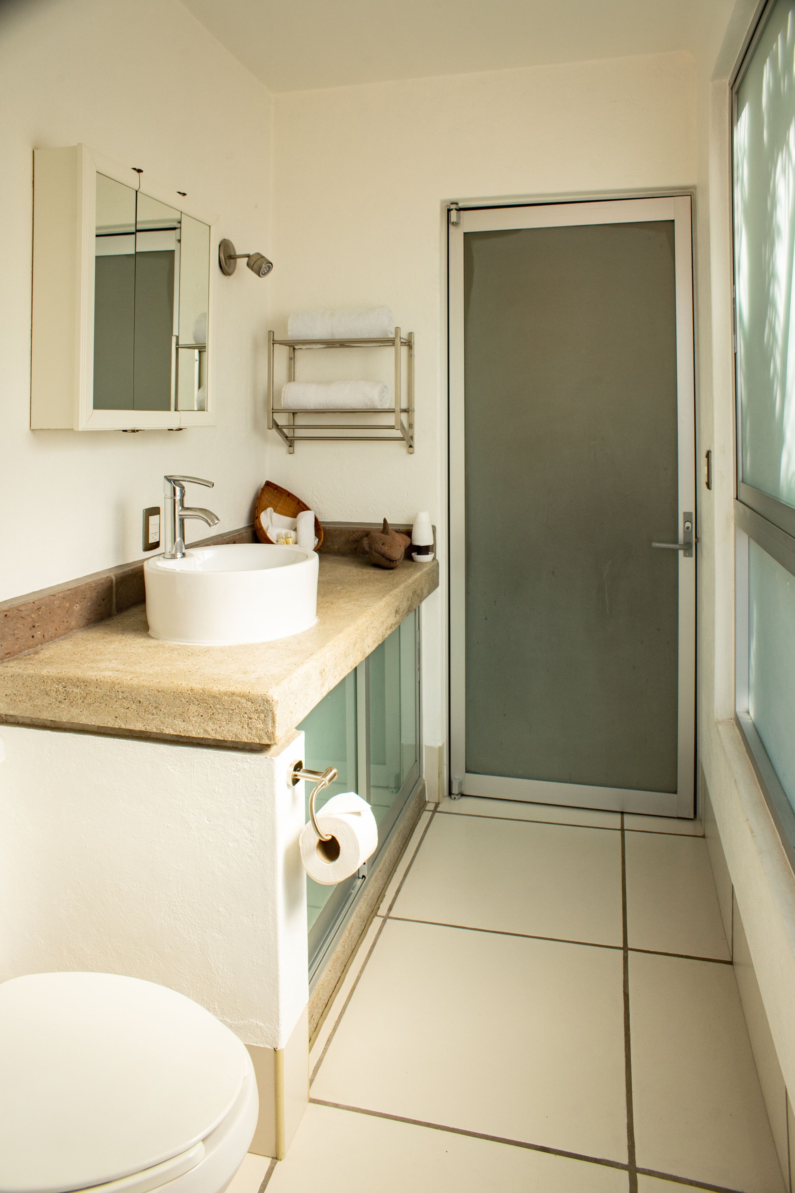 Une salle de bain équipée d’un lavabo, de toilettes et d’une douche à parois en verre.