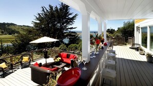 Eine Terrasse mit Gartenmöbeln, einem Essbereich und Blick auf die Landschaft.