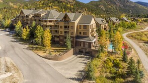 Un hôtel à plusieurs étages doté d’une cour intérieure, entouré d’arbres et de montagnes.