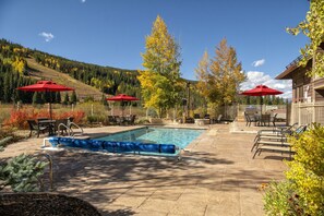 A pool area with a clear blue pool, red umbrellas, and outdoor seating. - 1BR+Murphy Bed/2 Bath in River Run Village close to the Keystone gondola (Keystone)