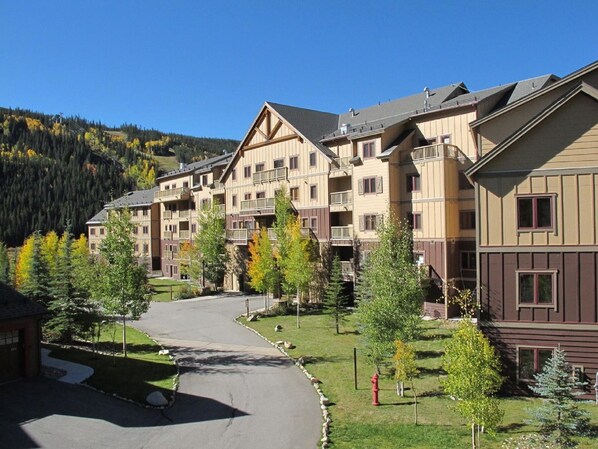 A multi-story hotel with a central courtyard, surrounded by trees and a mountain backdrop. - 1BR+Murphy Bed/2 Bath in River Run Village close to the Keystone gondola (Keystone)