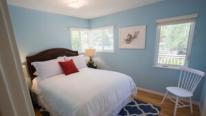 A bedroom with a bed, a chair, a nightstand, and a window. - Napa Valley Retreat in Calistoga! (Calistoga)