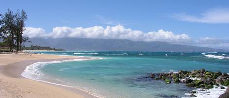 Una playa cerca, sillas reclinables de playa, toallas de playa