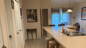 A kitchen with a white countertop, a sink, and a bar stool. - Pet-Friendly Island Retreat | No Weight/Breed Limits | 1mi Clayton’s Beach Bar (South Padre Island)