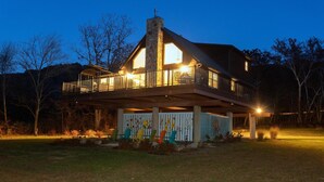 A two-story house with a balcony and a covered porch area. - Chalet In West Virginia on the Cacapon River. Sleeps 8 (Great Cacapon)