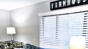 A living room with a grey sofa, patterned cushions, a lamp, and a sign that reads "FARMHOUSE". - Lake Front unit ready 4 you!  - sleeps 12 in beds, w/king bed, WiFi, pets (Crossville)