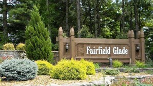 A wooden sign with the text "Fairfield Glade" surrounded by a garden with various plants and flowers. - Lake Front unit ready 4 you!  - sleeps 12 in beds, w/king bed, WiFi, pets (Crossville)