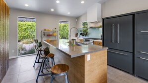Una cucina moderna con una grande isola, sgabelli da bar e forno integrato.