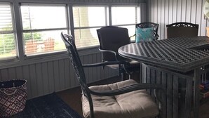Une pièce avec une table et des chaises, de grandes fenêtres et un tapis à motifs.