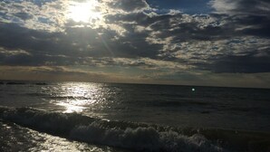 Une plage avec des vagues et un ciel nuageux.