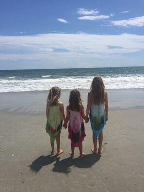 Three children holding hands on a sandy beach with the ocean in the background. - Ocean View Family Home! Games, Hammocks & Chill Space Underneath. Walk to Shops! (Ocean Isle Beach)