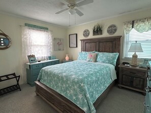 A bedroom with a bed, dresser, vanity, and a ceiling fan. - Ocean View Family Home! Games, Hammocks & Chill Space Underneath. Walk to Shops! (Ocean Isle Beach)