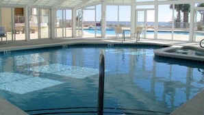 En inomhuspool med fantastisk utsikt över havet genom stora fönster.