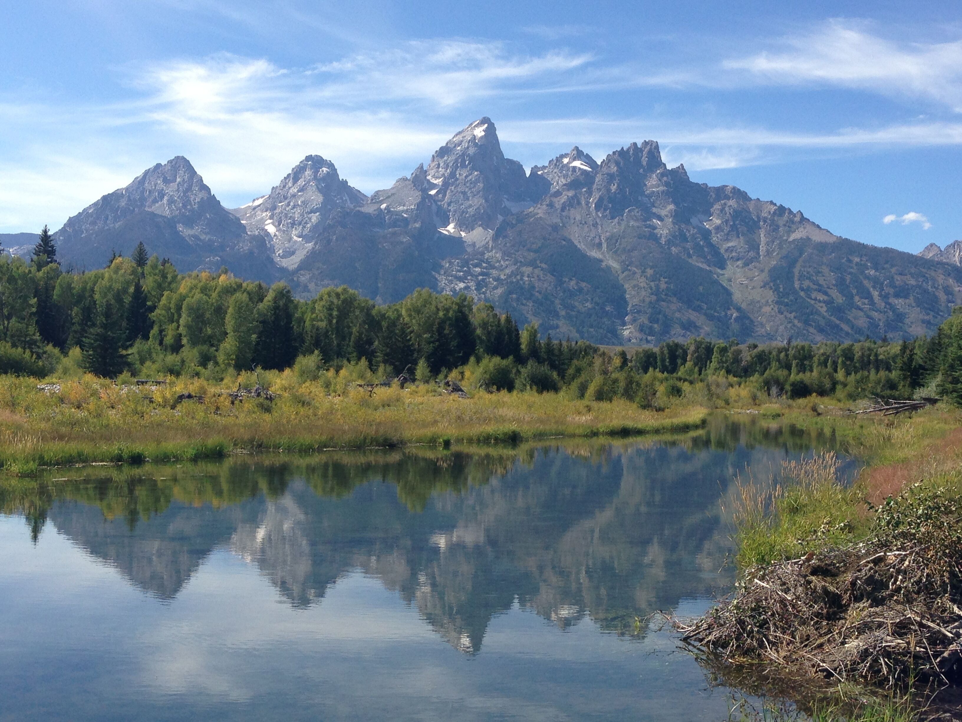 Paisaje montañoso con un lago tranquilo que refleja las cumbres.
