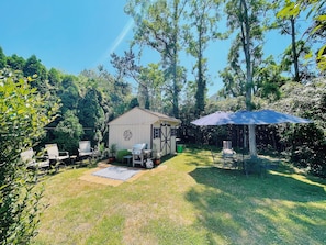 Relax in a serene backyard with a well-maintained lawn, patio, and lush greenery.