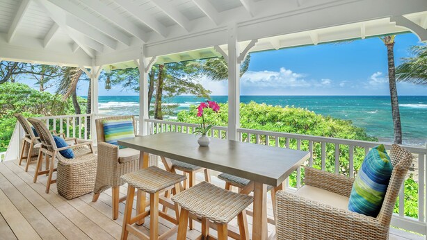 A covered outdoor seating area with wicker furniture and a view of the ocean. - Luxury Beachfront Home in Haena AC, Pool  TVNC5141 (Hanalei)