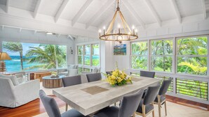 A spacious dining area with a large table, chairs, and a chandelier. - Luxury Beachfront Home in Haena AC, Pool  TVNC5141 (Hanalei)