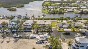 A marina with boats docked, surrounded by residential buildings and a waterway. - The Bokeelia Boathouse, waterfront, Boat Dock, Pine Island, Florida (Bokeelia)