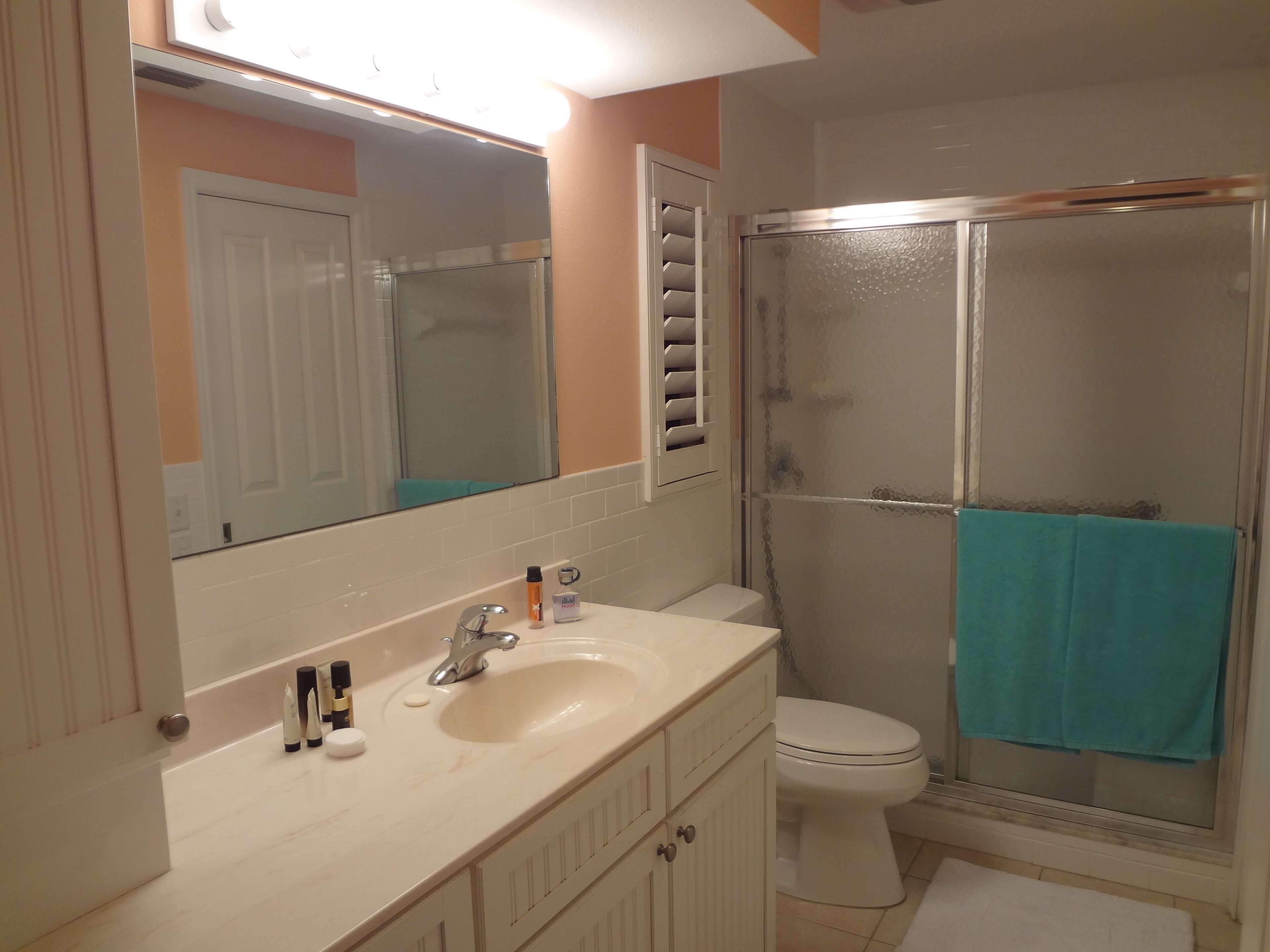 Ein Badezimmer mit Waschbecken, Spiegel, Toilette und Dusche.