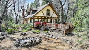 Eine Holzhütte mit einer Terrasse, umgeben von Bäumen.