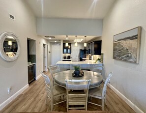 A modern kitchen with dark cabinets, a central island, and pendant lighting. - Amazing top floor view in a newly renovated Lake Travis Condo on Private Island (Lago Vista)