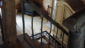 A wooden cabin interior with a staircase leading to an upper level.