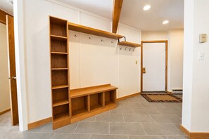 A hallway with a built-in bench, wooden shelves, and hooks on the wall. - True Ski In / Out with Amazing Views, Garage, Elevator & Fireplace (Crested Butte)