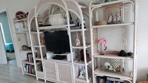 Ein weißer Körbotänze-TV-Schrank mit Regalen und einem Flachbildfernseher.
