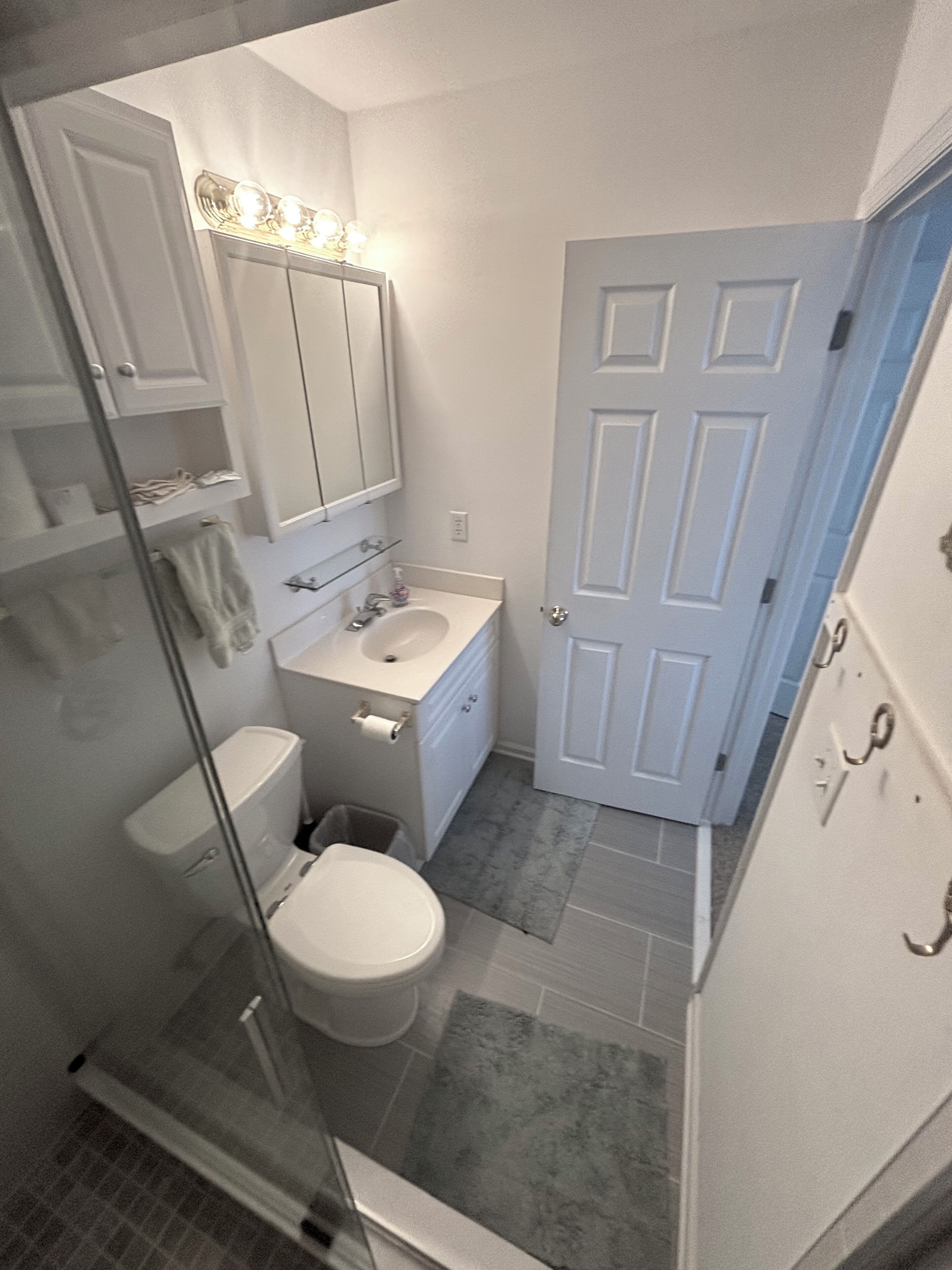 A bathroom with a toilet, sink, and shower.