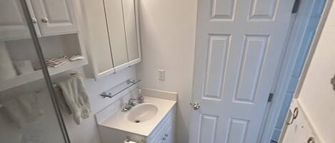A bathroom with a toilet, sink, and shower.