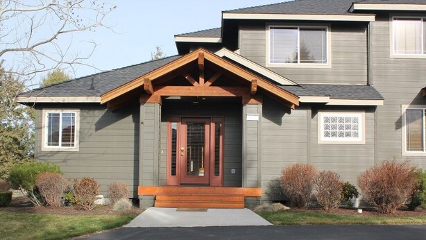 A two-story house with a front porch, a central door with sidelights, and a small window above the door. - Golden Escape- Private Hot tub, Dog Friendly (Redmond)