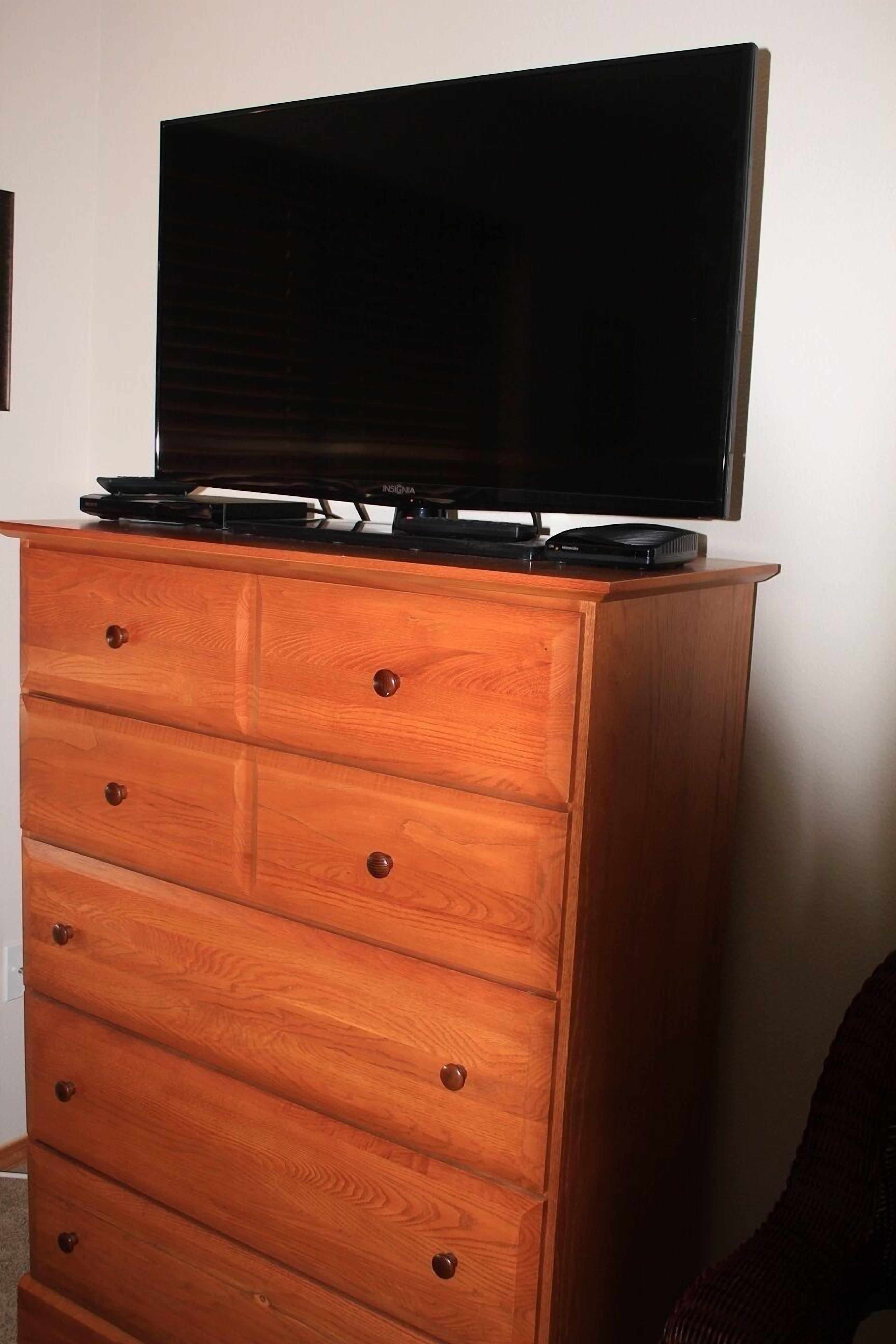 En byrå i trä med en platt-TV ovanpå.