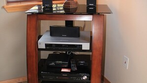 A wooden entertainment center with a lamp, speakers, and various electronic devices. - Golden Escape- Private Hot tub, Dog Friendly (Redmond)