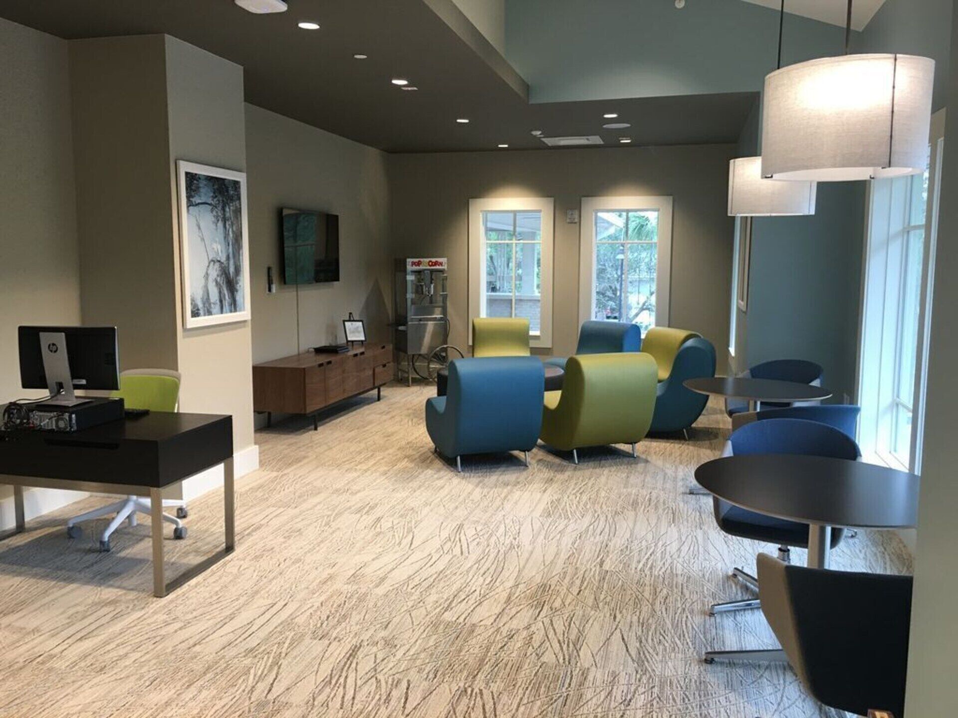 A modern office space with a desk, computer, chairs, and a coffee machine.