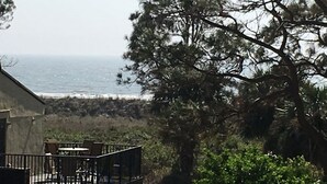 A coastal property with a balcony overlooking the sea, surrounded by trees. - Ocean View Villa with Amazing Resort Amenities -- just steps from the beach!!! (Hilton Head Island)