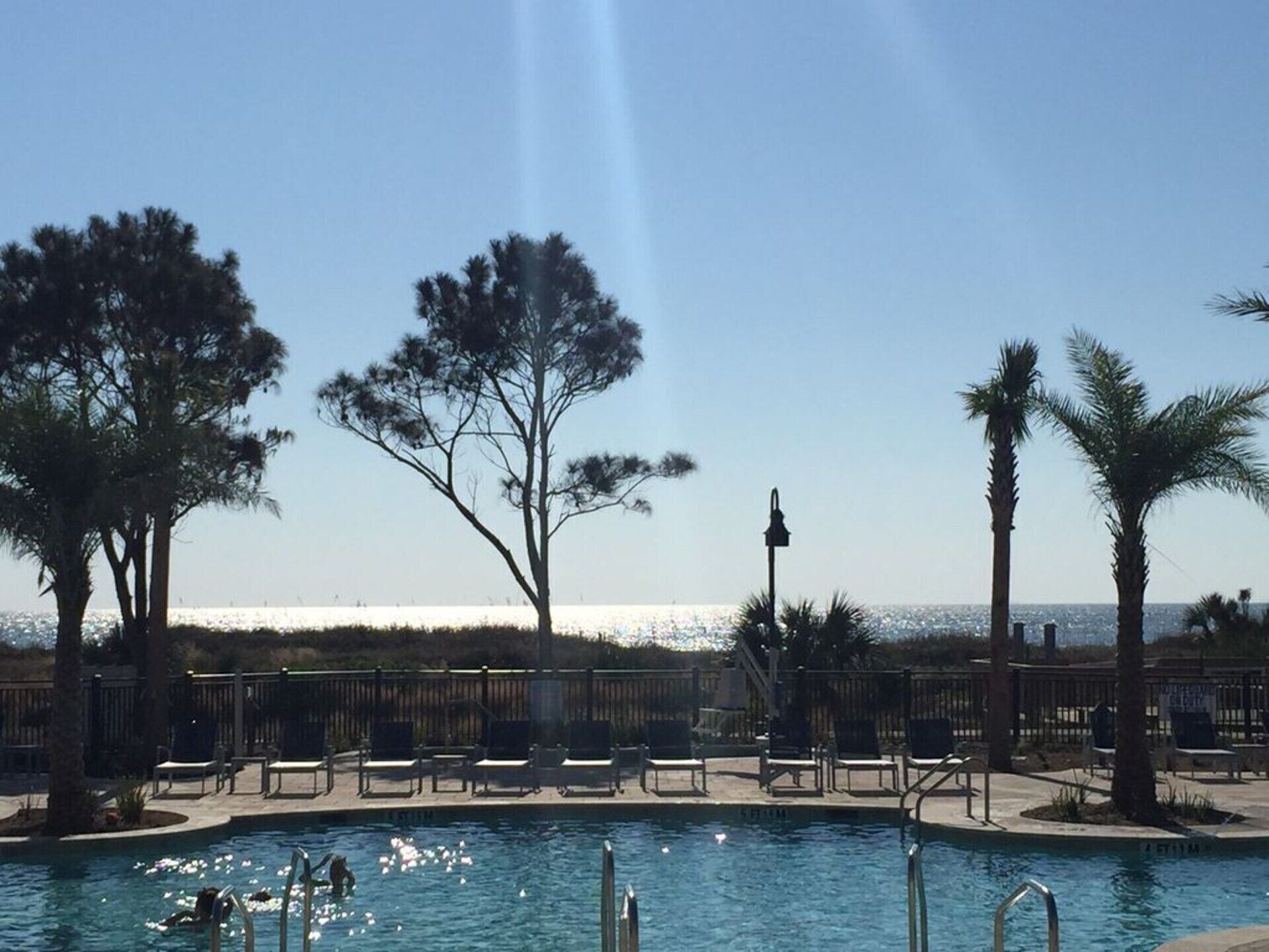 Area piscina con sedie a sdraio e vista sull'oceano.