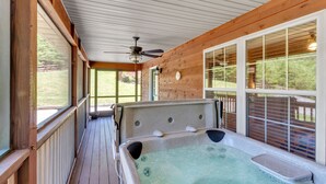 A hot tub on a wooden deck with large windows and a ceiling fan. - 4BR + Kid Sleep area-“Bunkhouse”=5BR-3BA-Sleeps 12 (Sevierville)