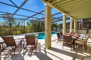 An outdoor patio with a pool, wicker furniture, and a pergola structure. - 5BR Villa • South-Facing Pool & Spa • No Rear Neighbours • Near Disney (Davenport)