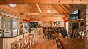 Un interior de madera con cocina, comedor y chimenea.