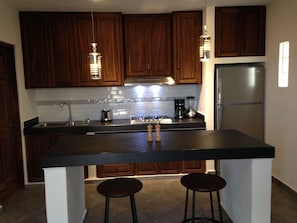 Enjoy cooking in this well-equipped kitchen with a refrigerator, coffee maker, and island seating for two.