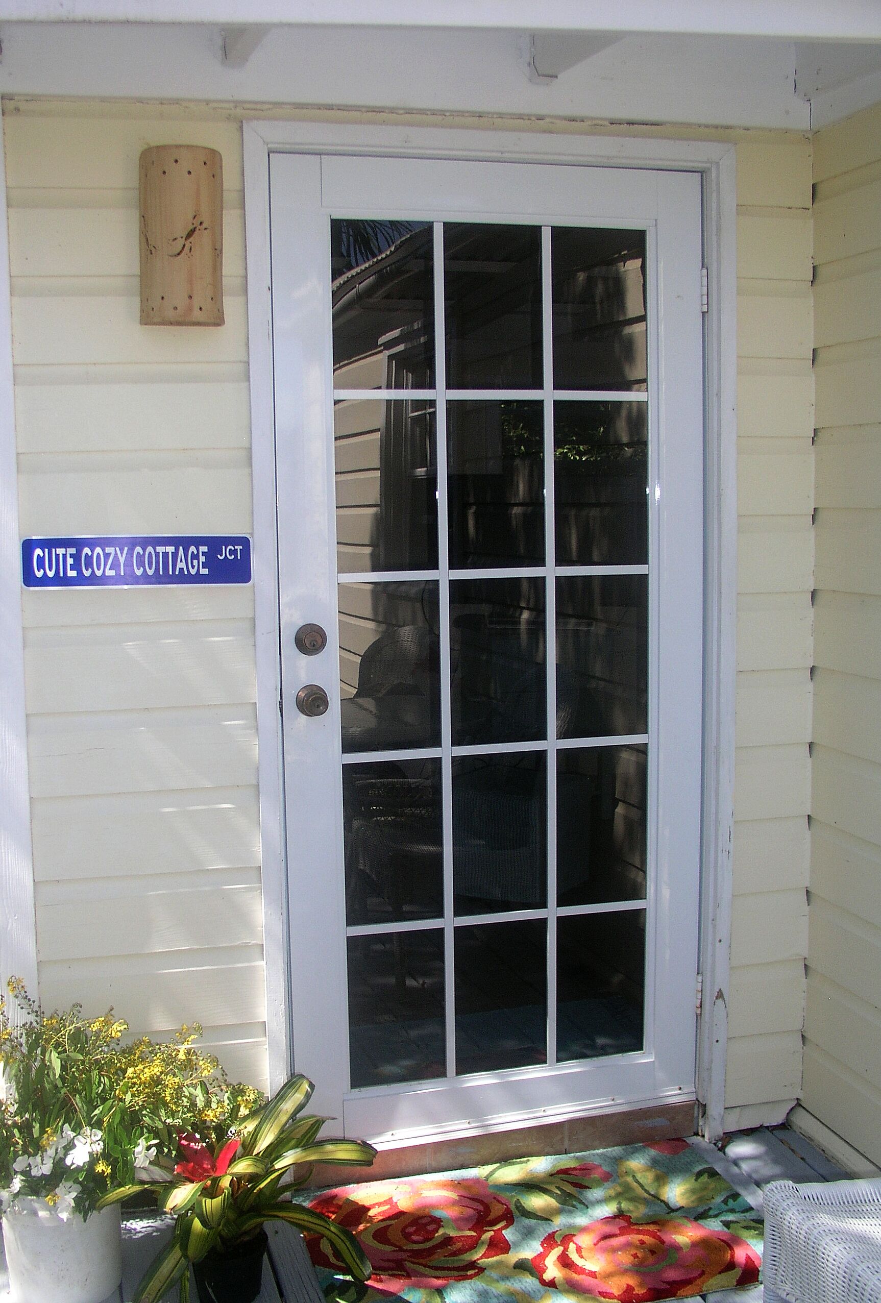 Une porte d’entrée avec une pancarte indiquant : « Charmant petit chalet, JCT ».