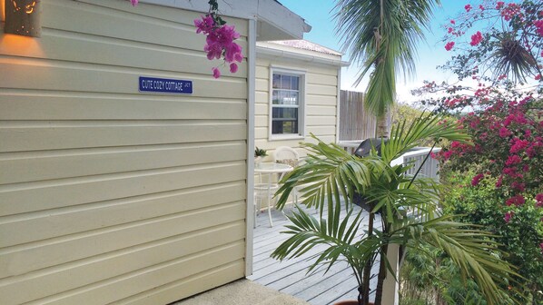 A house with a sign reading "CUTE COZY COTTAGE JCT."