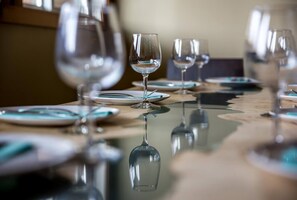A dining table with several wine glasses and plates, reflecting on the surface. - KR410 by Simply Kimberley | Ski-In/Out + Private Hot Tub (Kimberley)