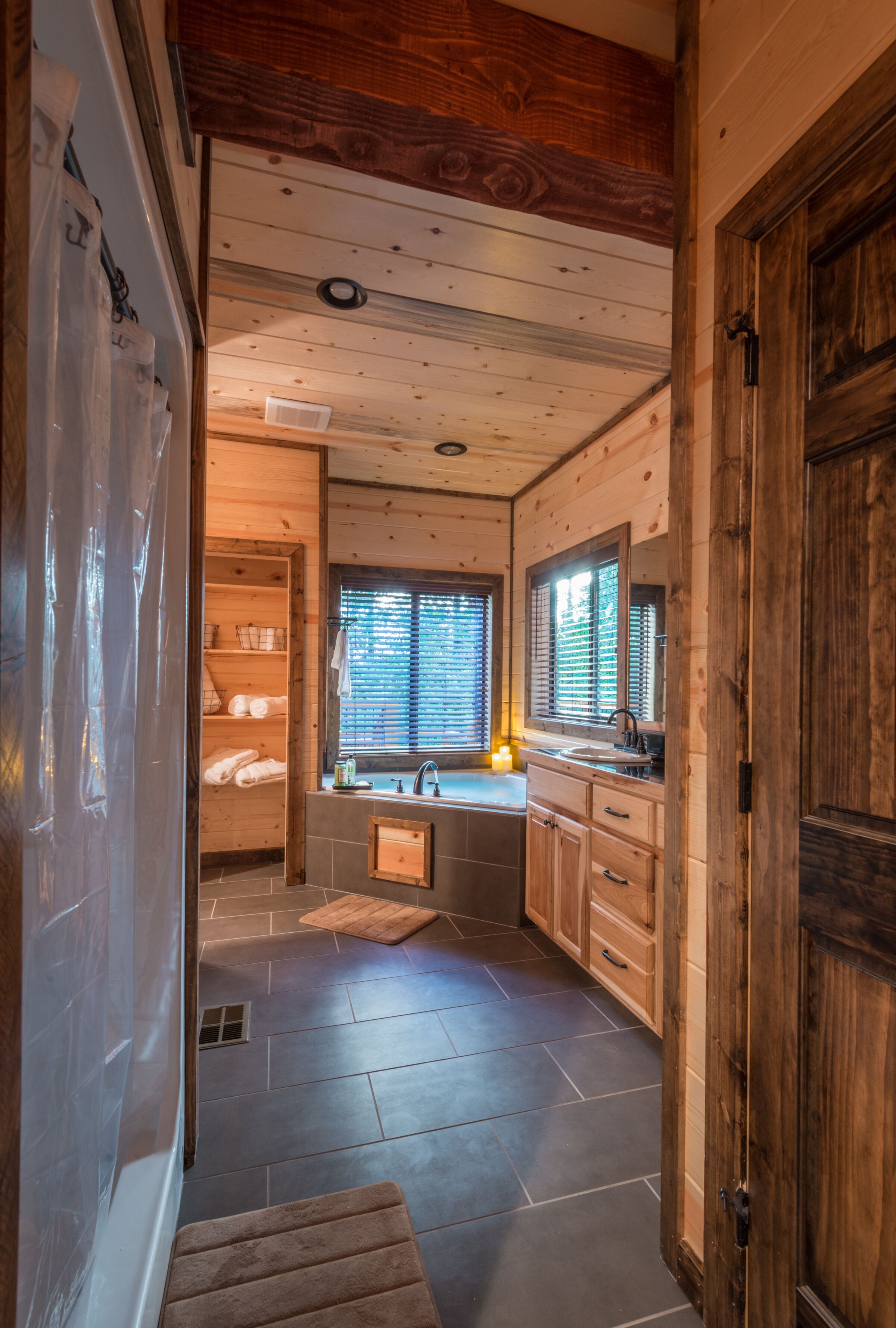 Un intérieur en bois avec une salle de bain comprenant un lavabo, un miroir et une fenêtre.