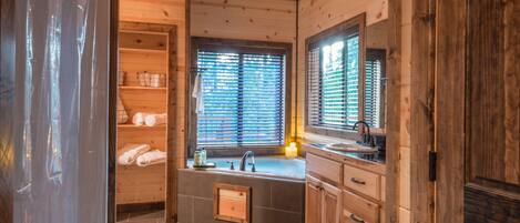 Un intérieur en bois avec une salle de bain comprenant un lavabo, un miroir et une fenêtre.